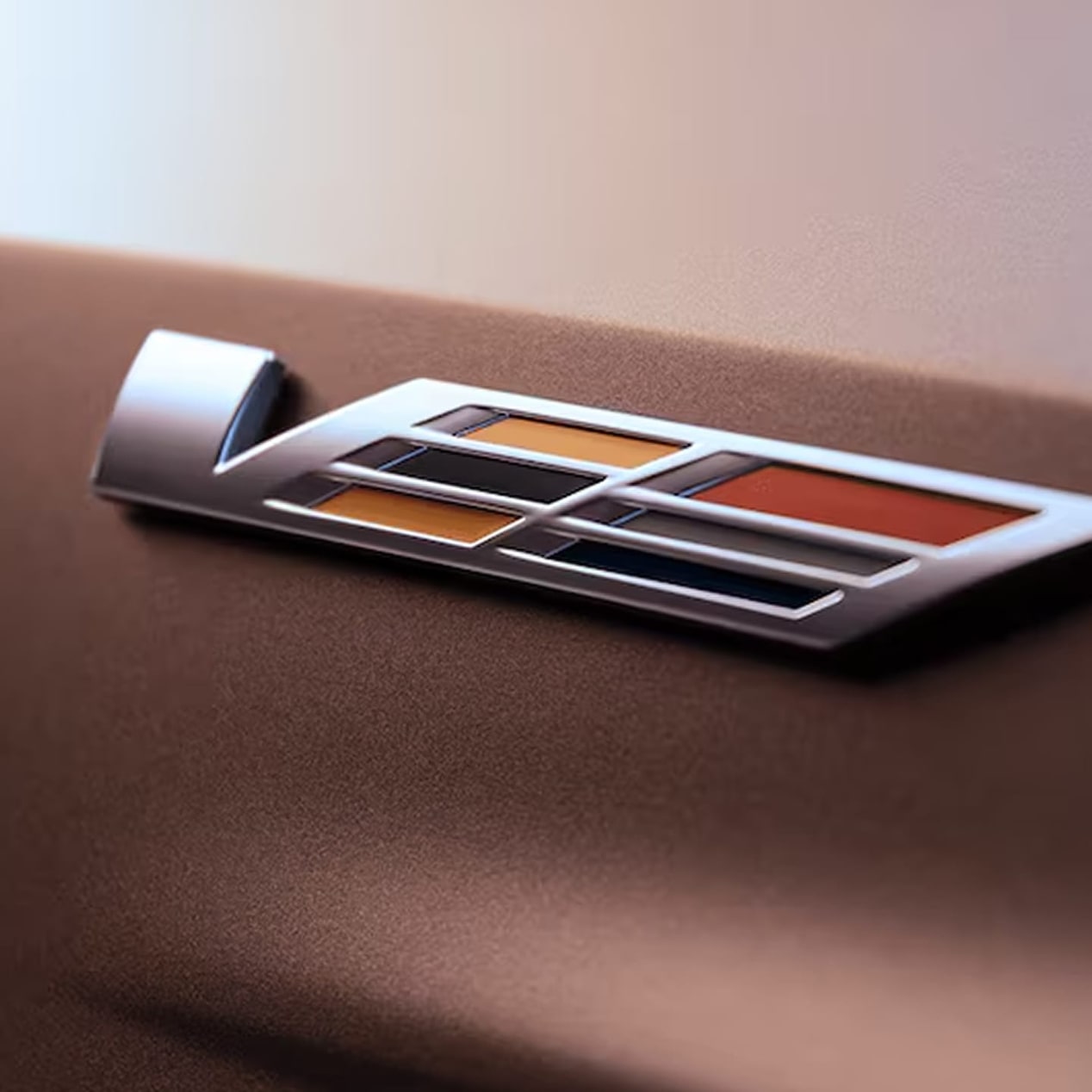 Nahaufnahme des ikonischen, glänzenden V-Series-Emblems des LYRIQ-V. Es kennzeichnet Cadillacs schnellstes Elektrofahrzeug aller Zeiten.