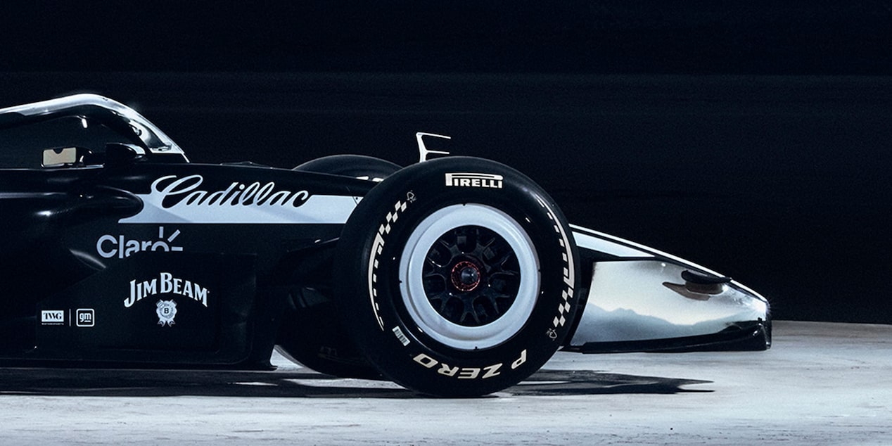 Front half of Cadillac’s F1 car, in profile, with sponsor’s names. On concrete floor with ‘General motors’ on wall behind.