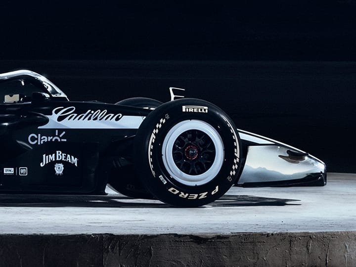 Front half of Cadillac’s F1 car, in profile, with sponsor’s names. On concrete floor with ‘General motors’ on wall behind.