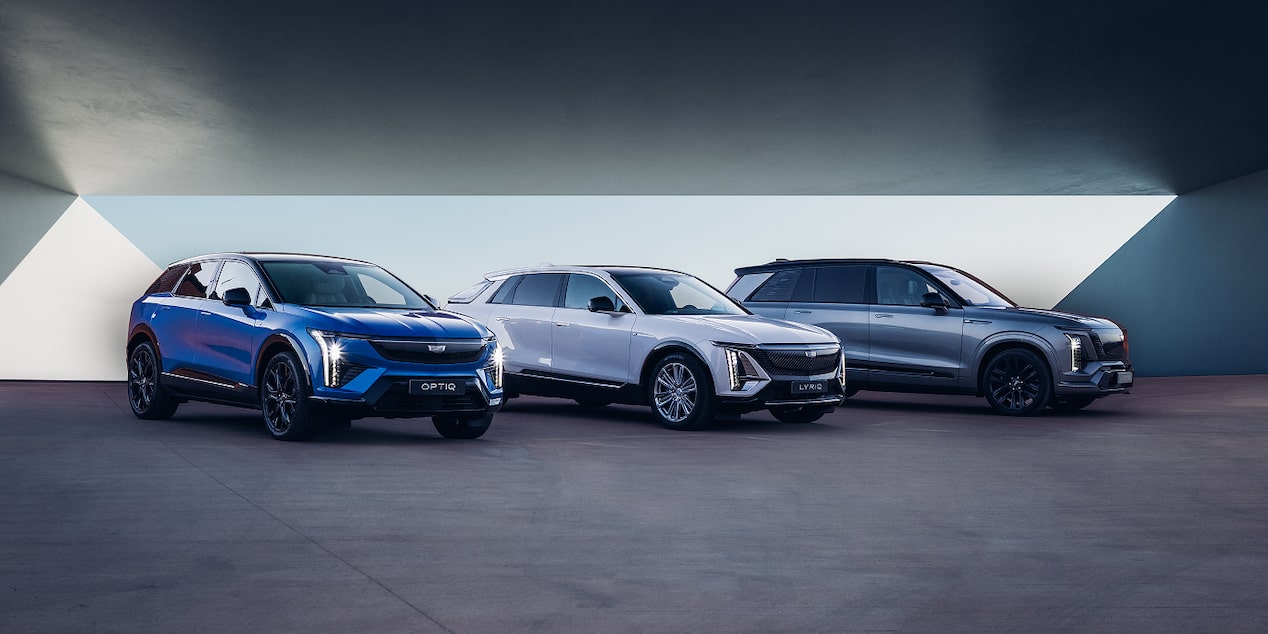 Trois des derniers modèles de SUV électriques Cadillac présentés côte à côte sur un espace dégagé, mettant en valeur les différents designs propres à chaque modèle.
