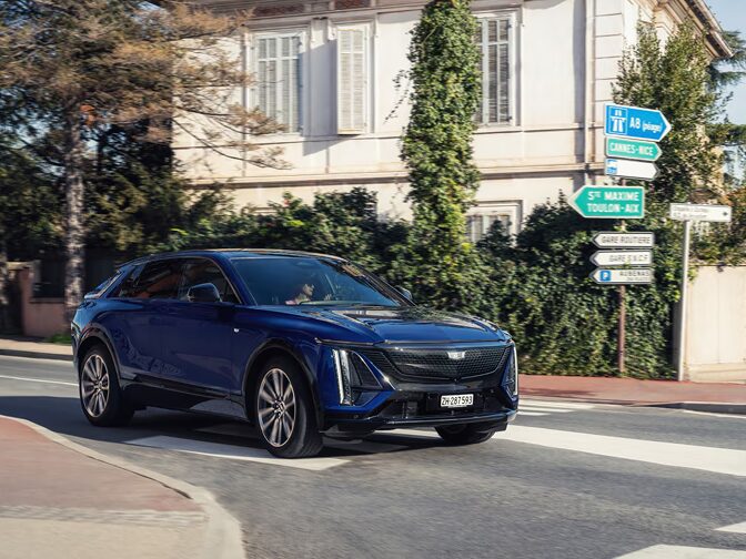 Dreiviertelansicht des Cadillac LYRIQ, der an einem Haus in der Provence, Frankreich, vorbeifährt.