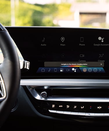 View of a Cadillac vehicle interior showing the digital display with charging related navigation options.